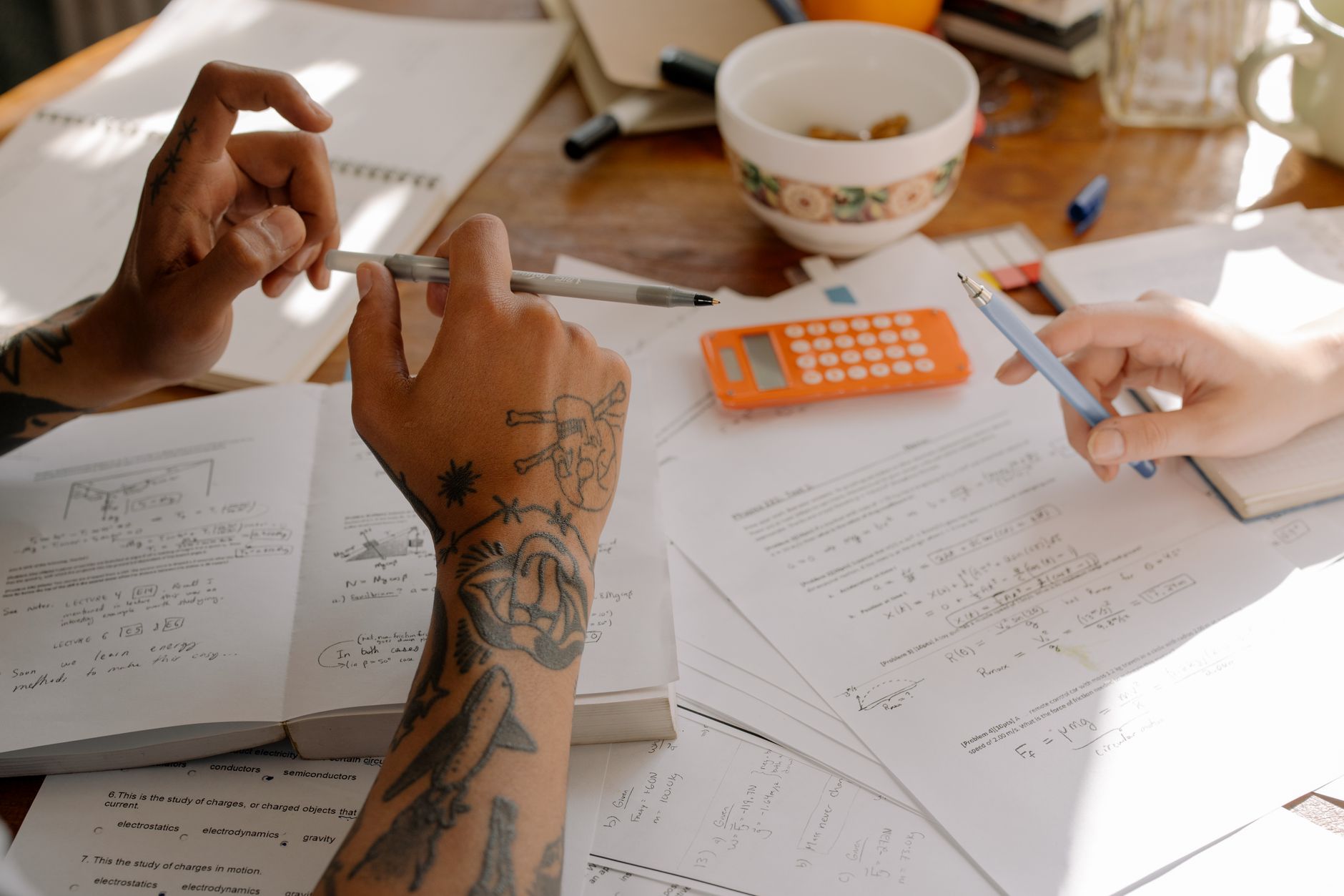 A maths tutor working through revision material with a student