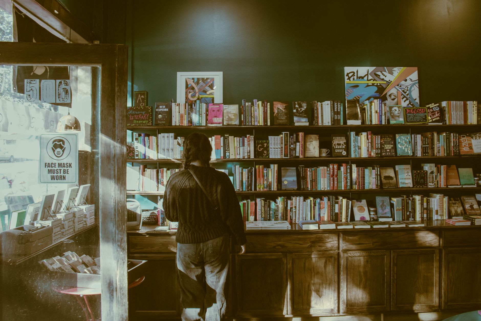 An independent bookshop owner setting up a recommendation display