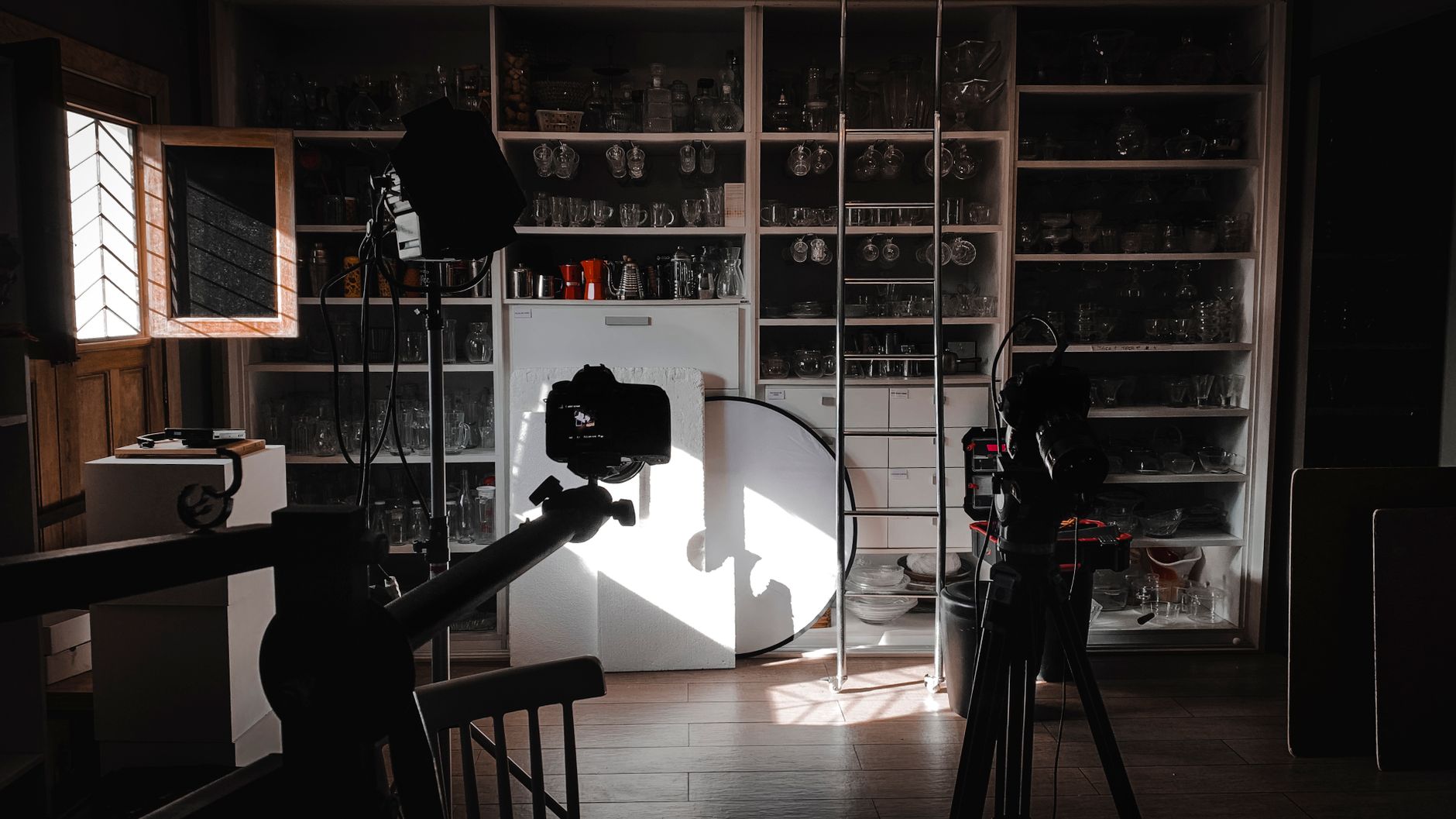 A seller using window light and a reflector card to photograph a product