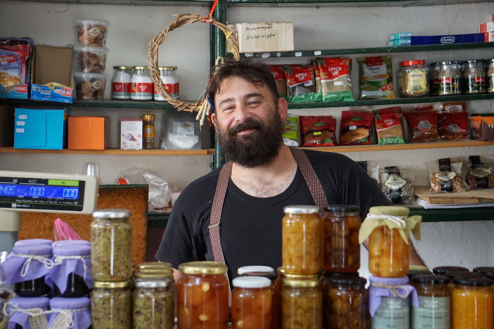 A shop owner welcoming a regular customer at the counter