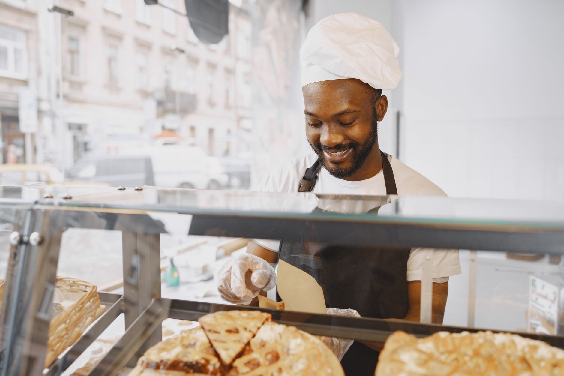 A baker giving a customer a free slice of cake on their birthday