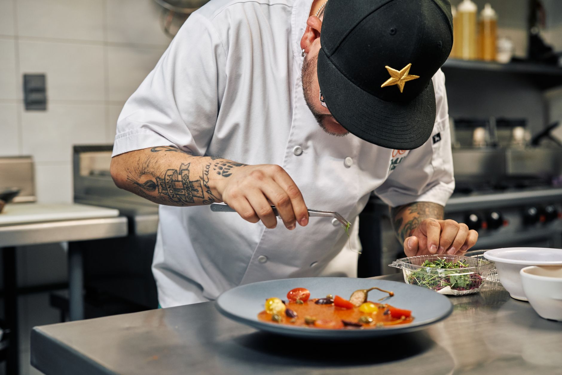A chef finishing a plate in a busy restaurant kitchen