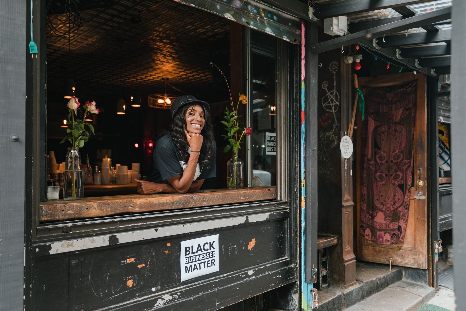 A restaurant owner welcoming diners at the entrance