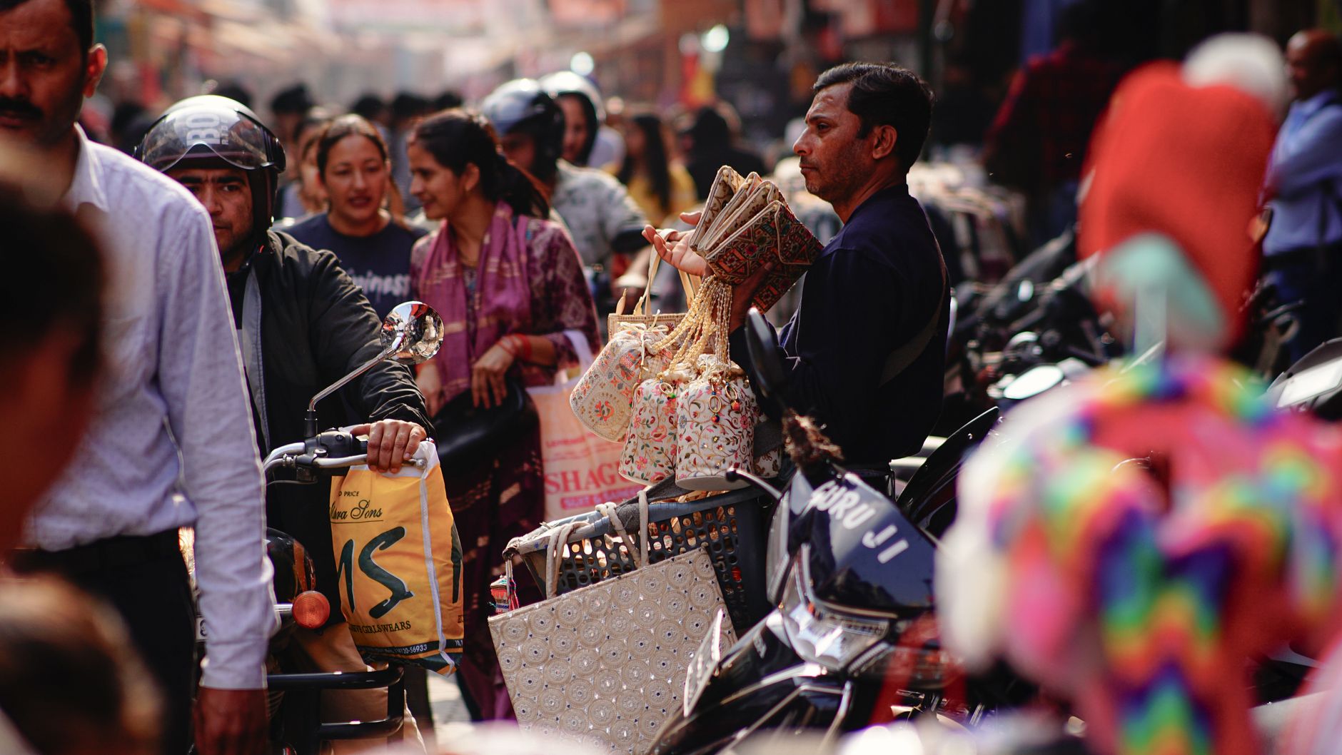 Shoppers carrying bags along a busy independent high street