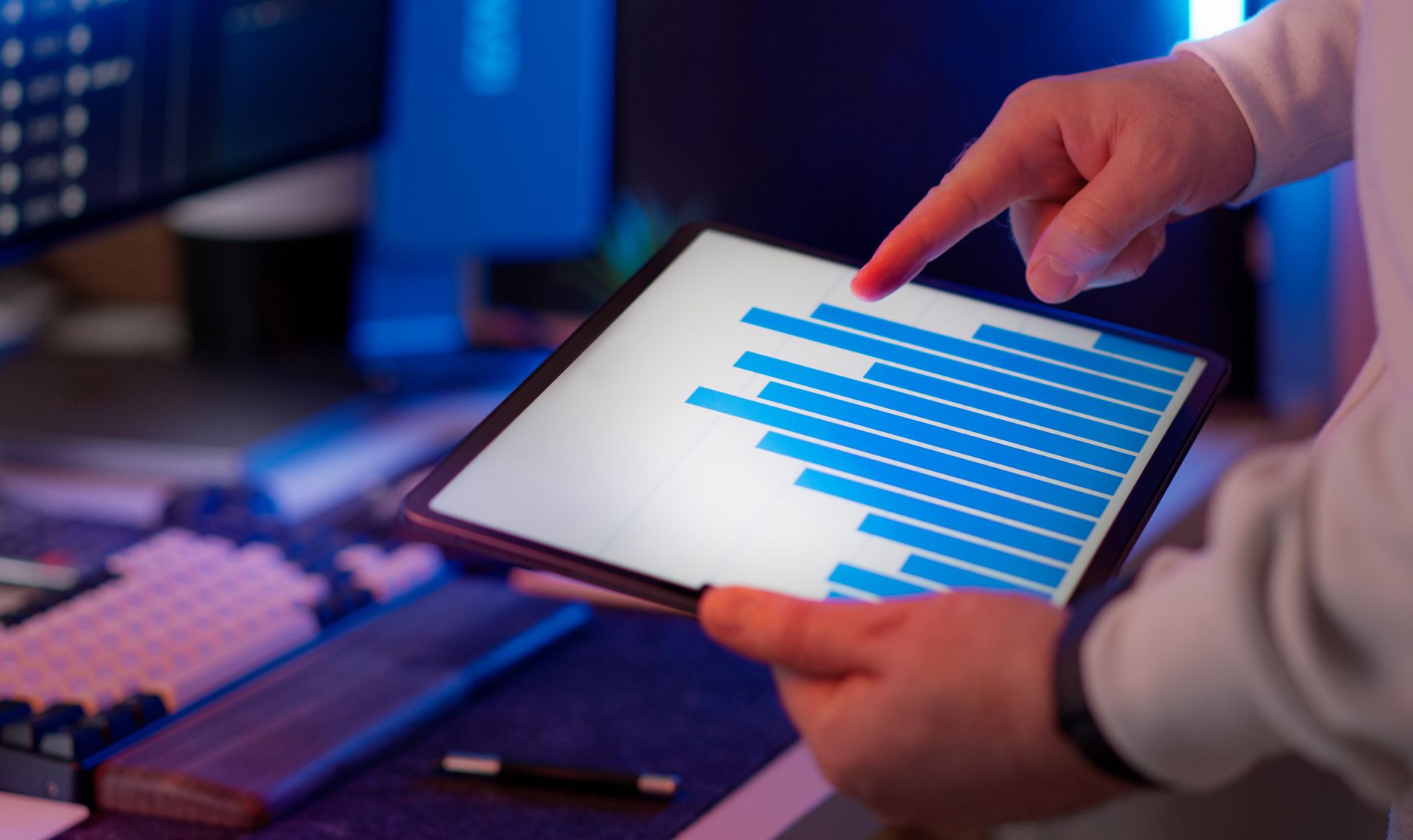 A founder reviews a metrics dashboard on screen, tracking acquisition cost, payback period and churn side by side.