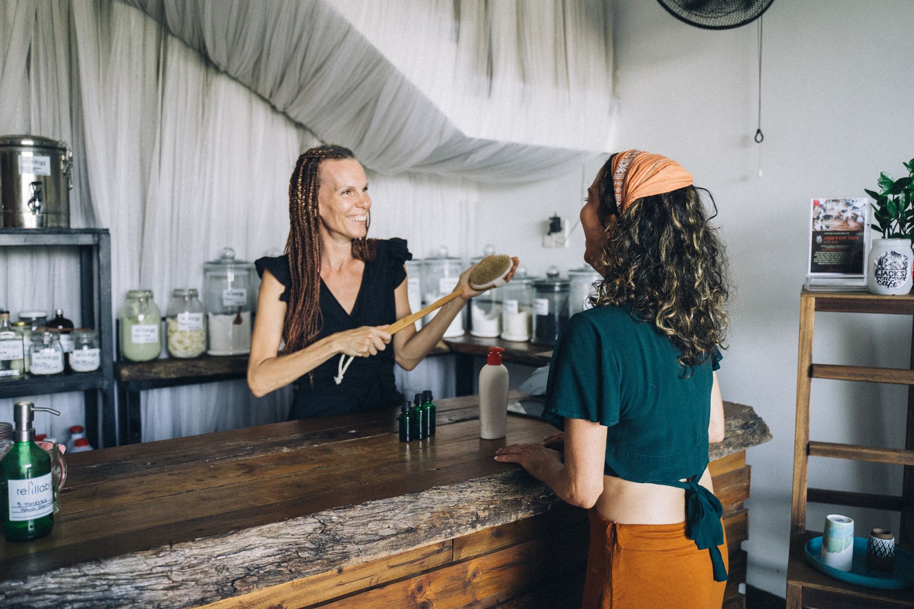 A shop owner having a friendly, unhurried conversation with a customer across a counter