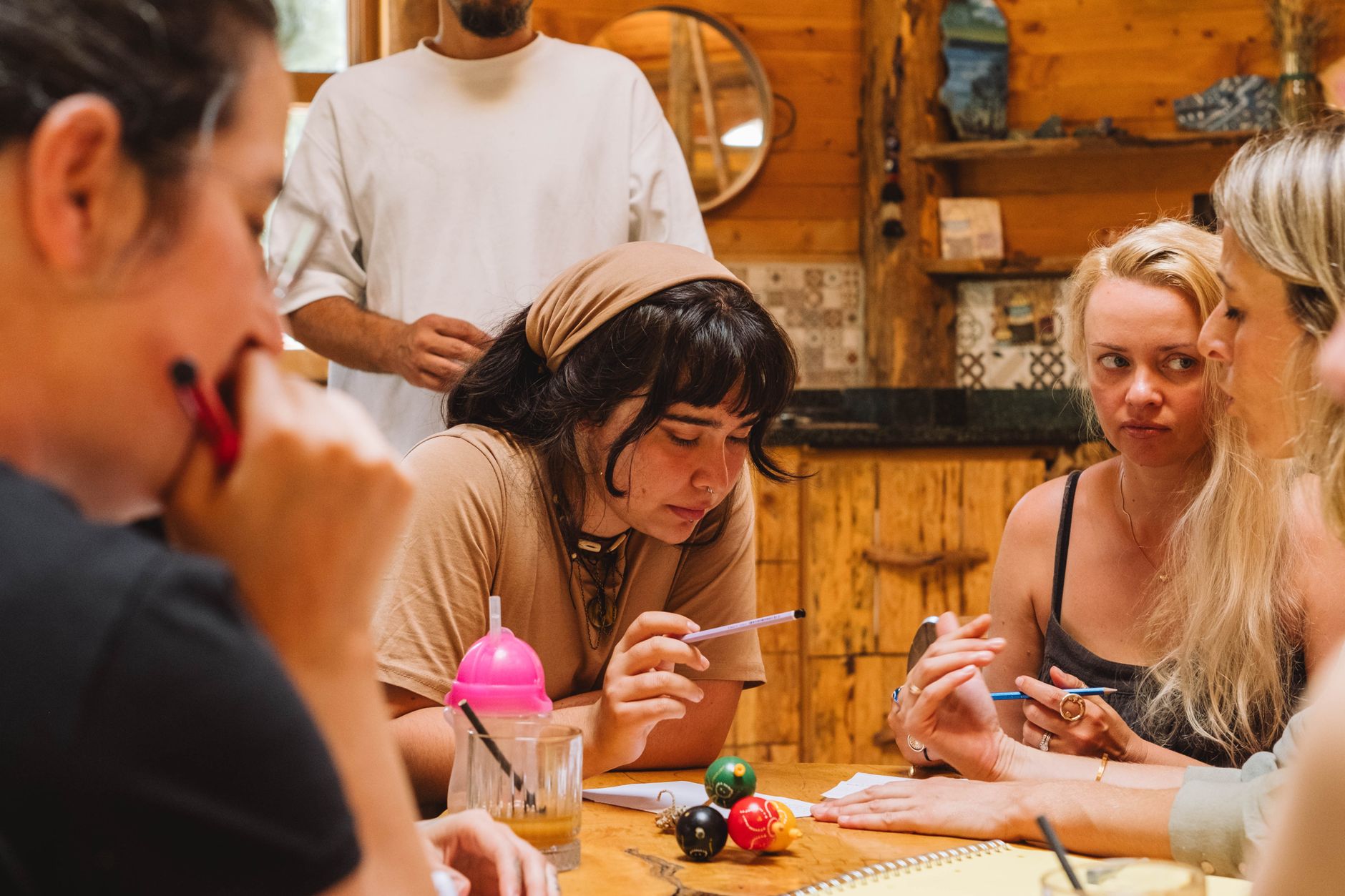 A small team meeting around a table with notebooks and coffee