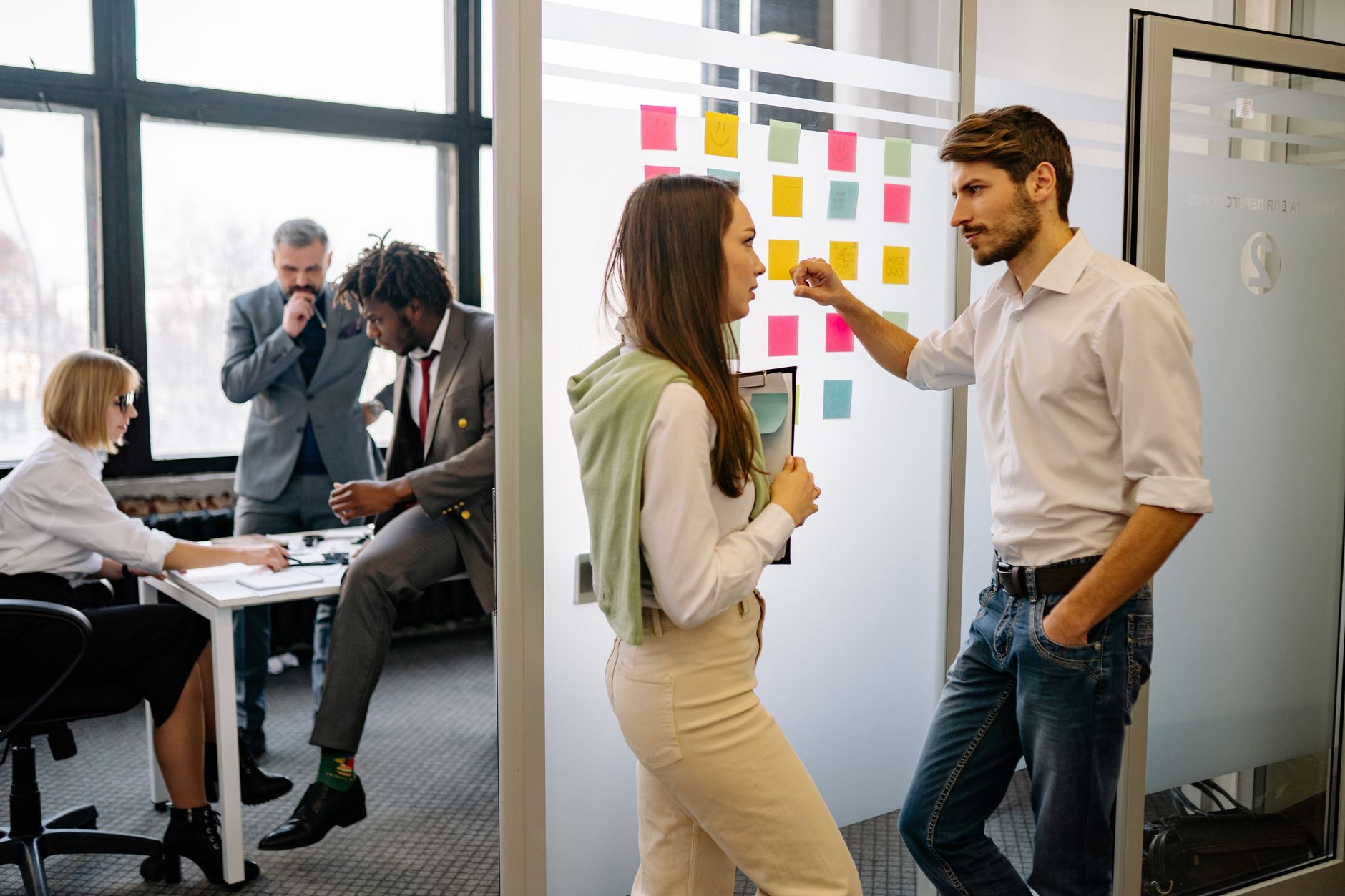 A small team planning the stages of their customer journey with notes on a wall