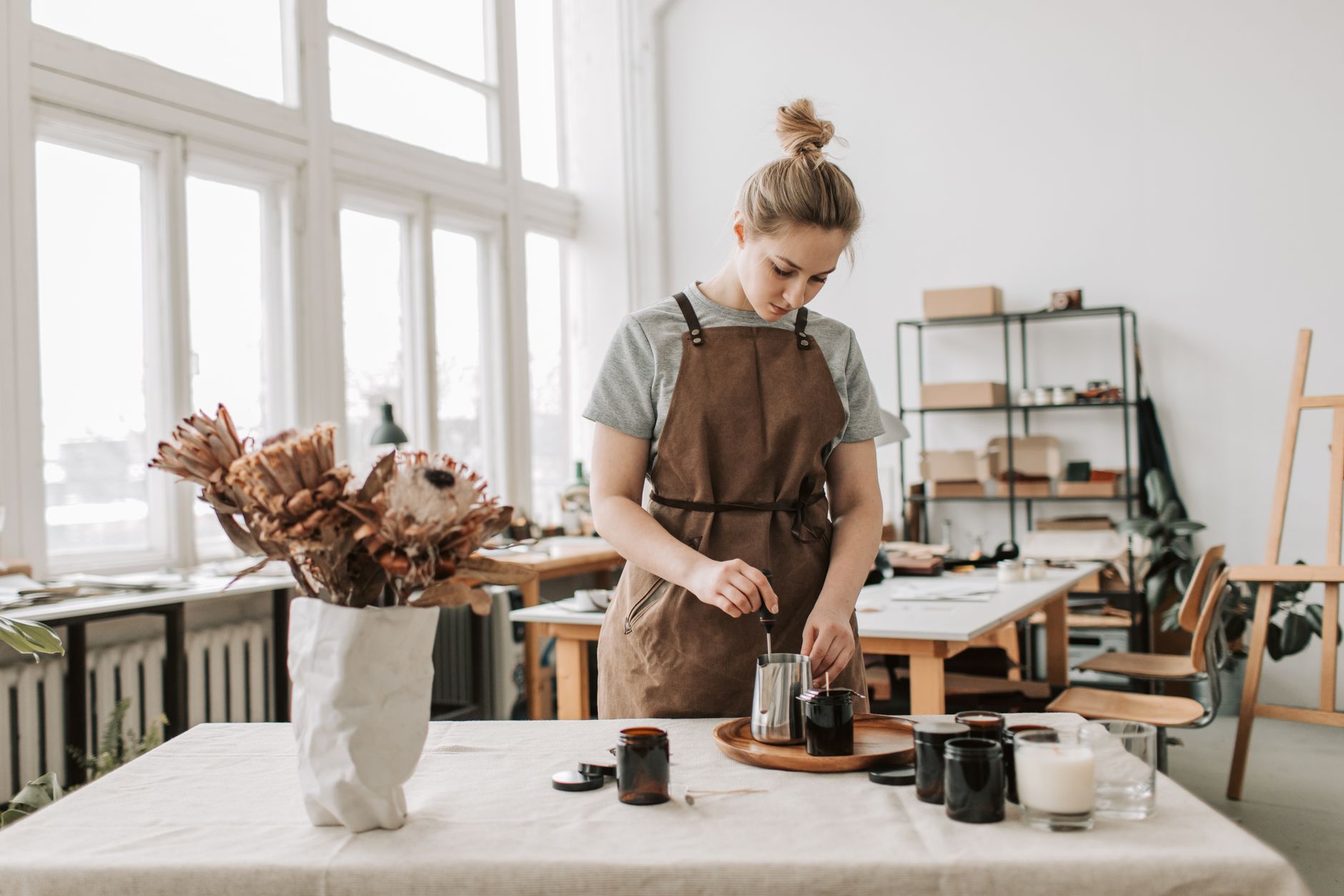A candle maker organising products by type in her workshop