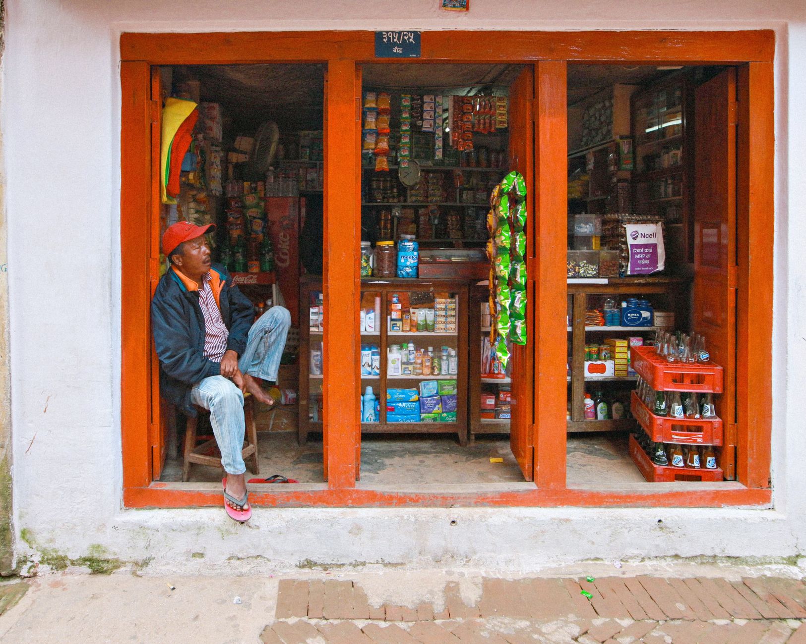A customer checking their phone while waiting outside a shop