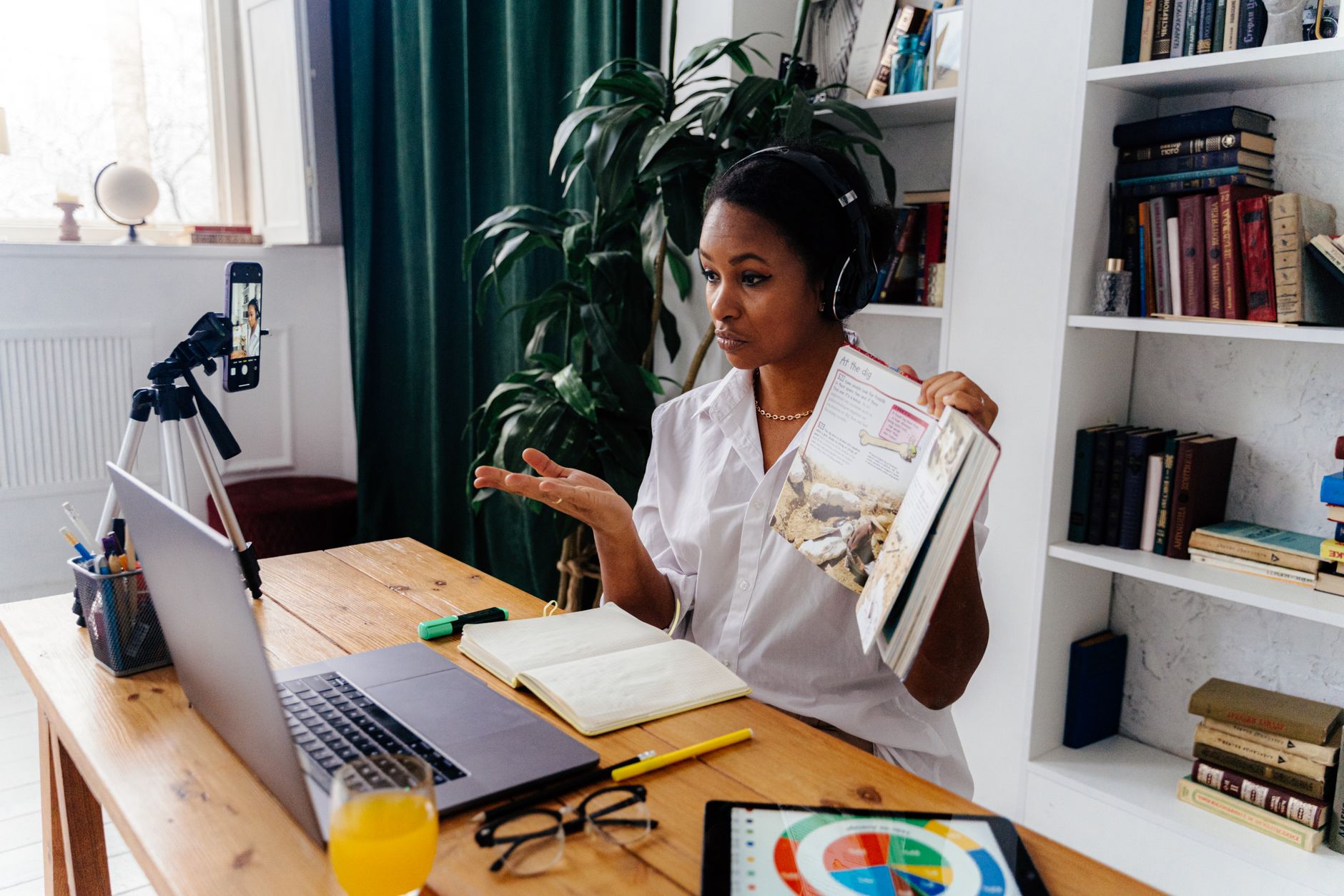A woman teaching an online lesson from home with a laptop and headset