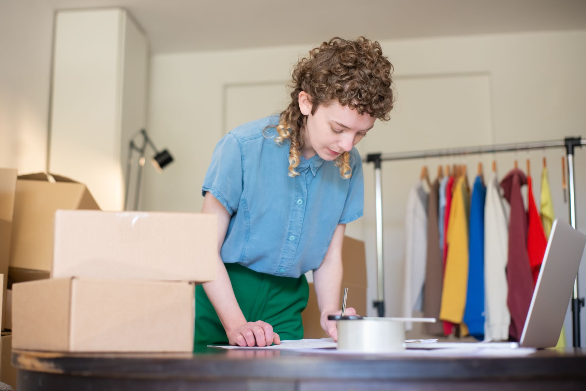 A woman happily packing handmade customer orders at a work table
