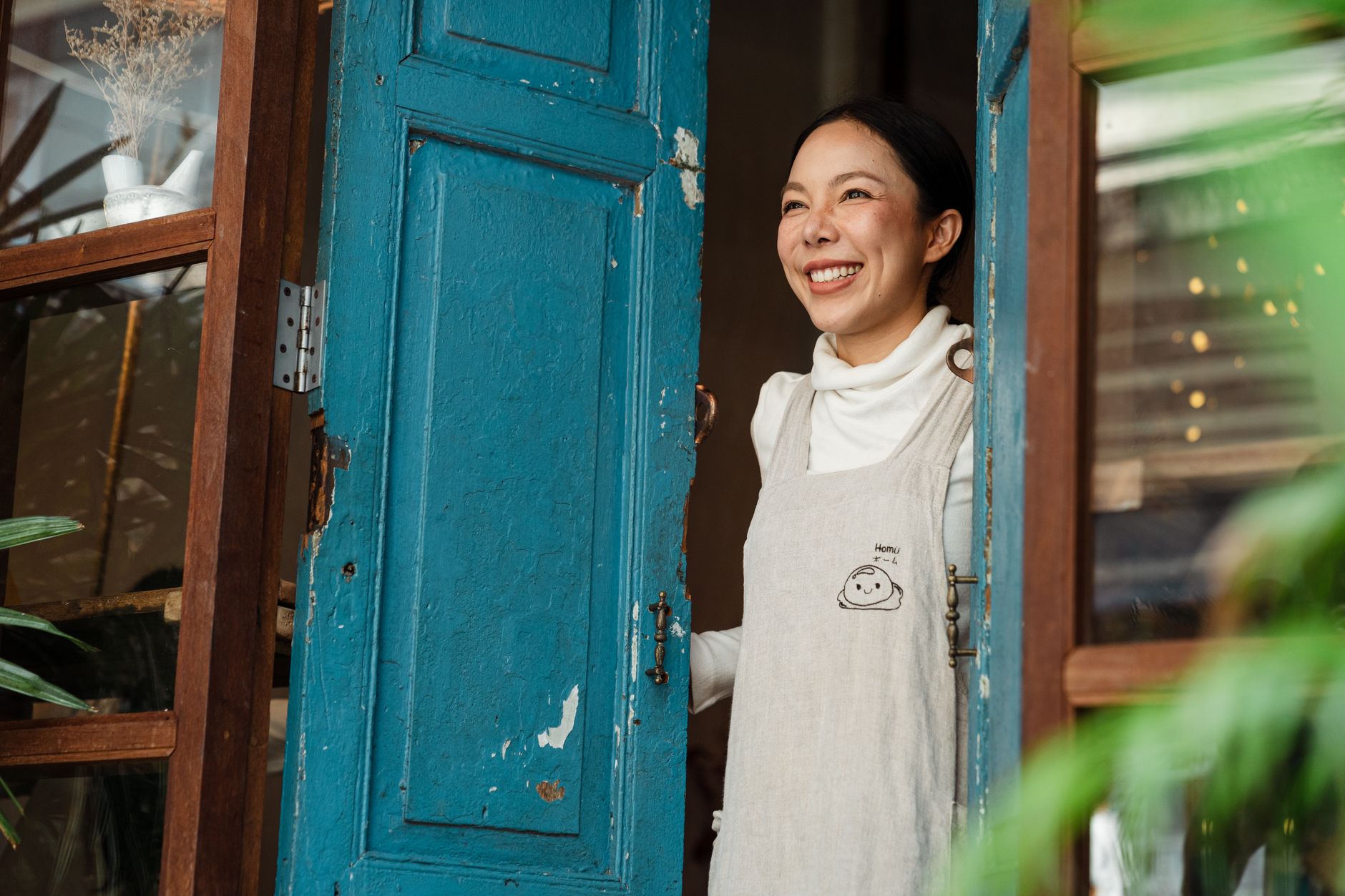A shop owner warmly greets a returning regular customer by name across the counter of a small independent store.