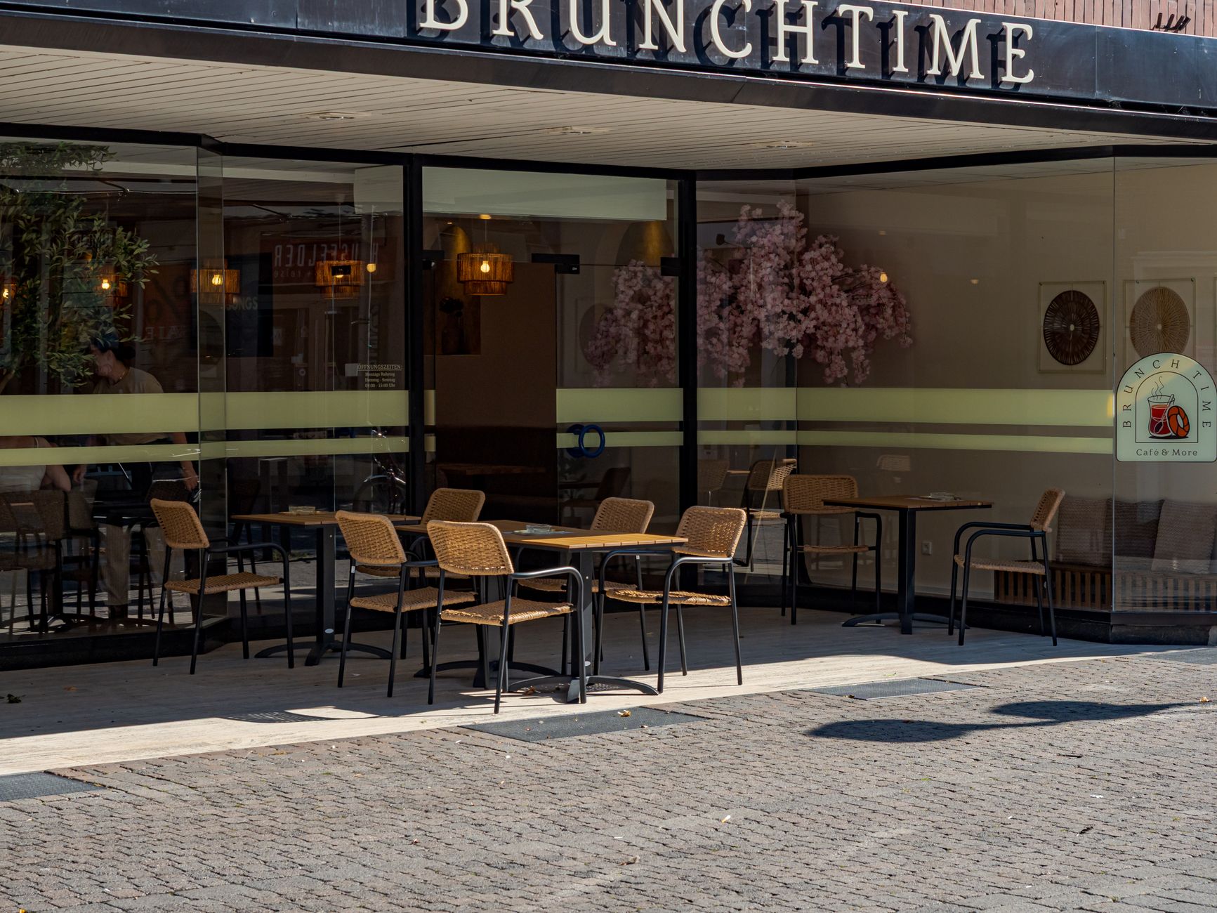 A cafe owner setting out pavement seating on a warm evening