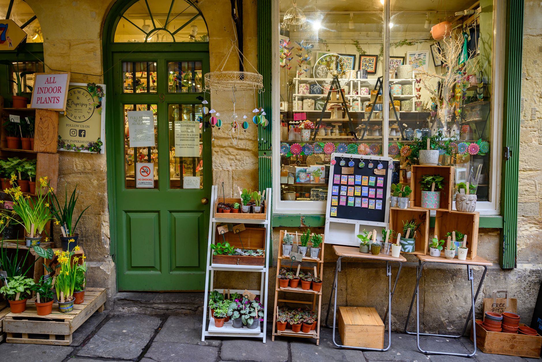 A shop owner setting up a summer window display on a UK high street