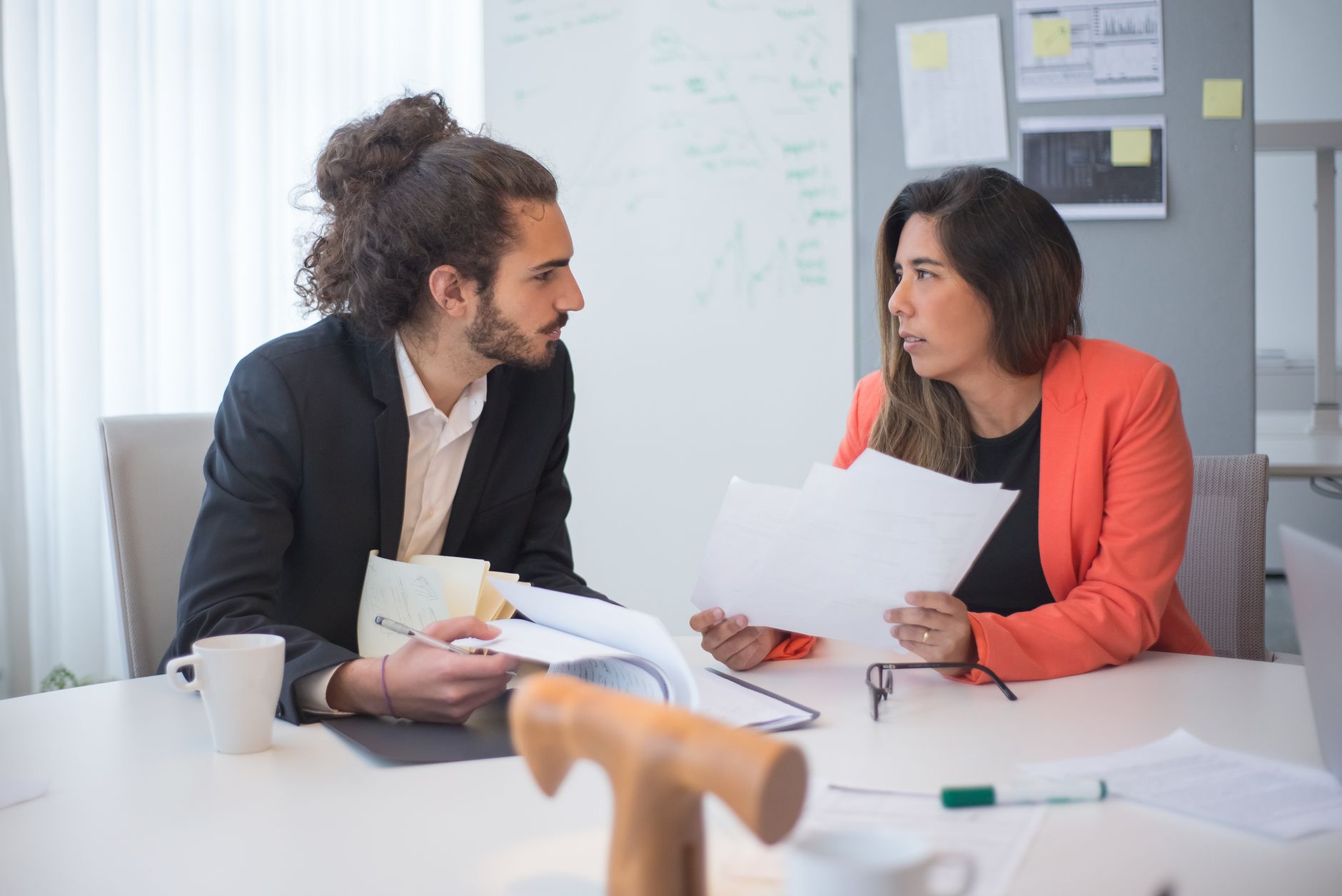 Two colleagues discussing strengths and weaknesses over notes