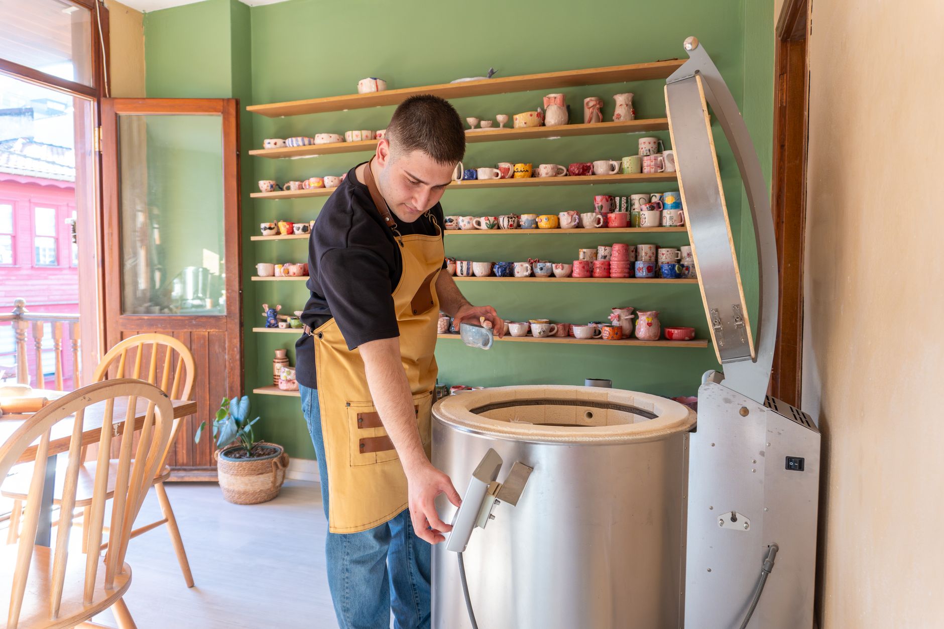 A potter setting aside a flawed piece from a finished kiln batch