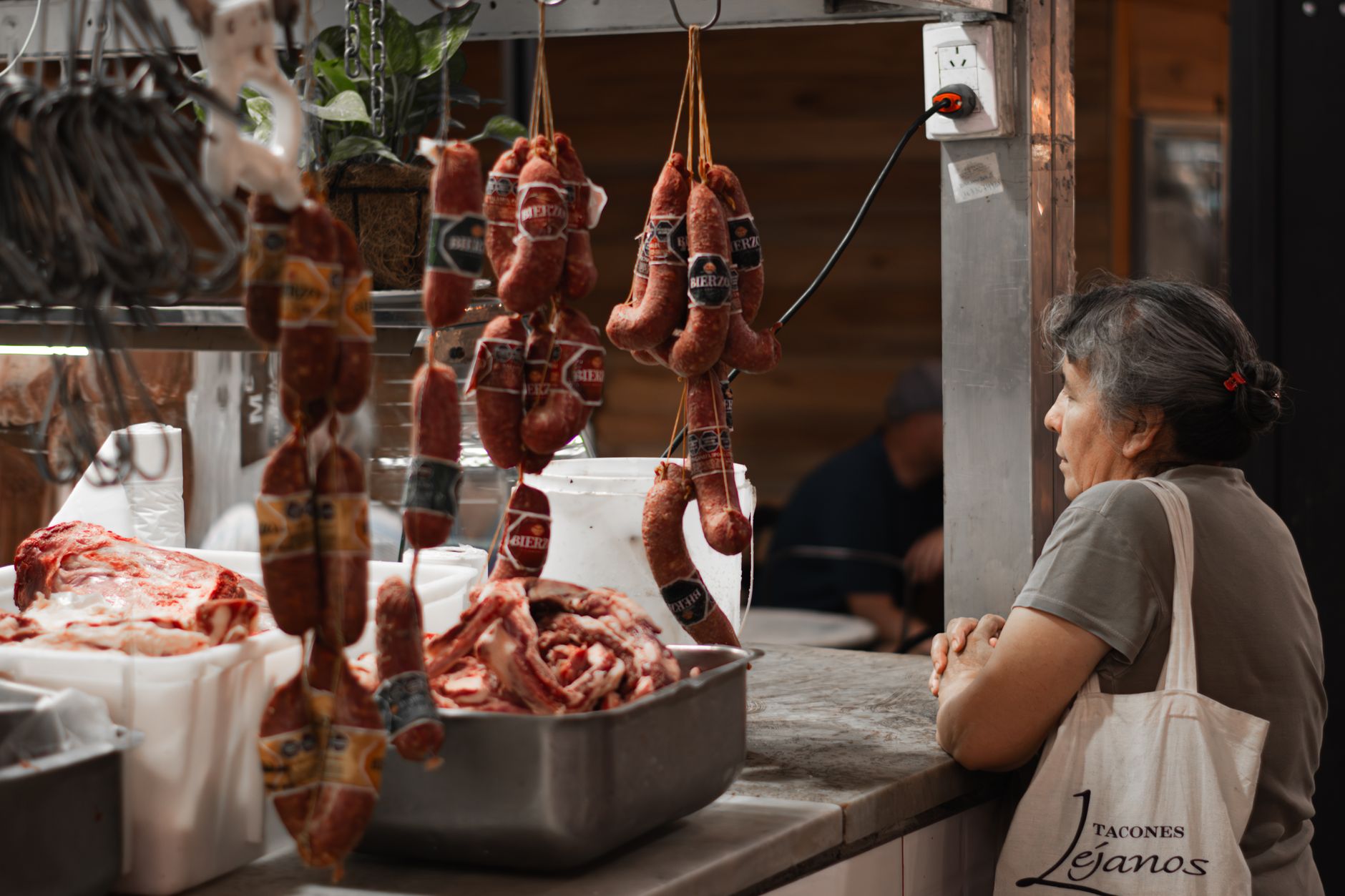 A butcher serving a loyal customer they know by name