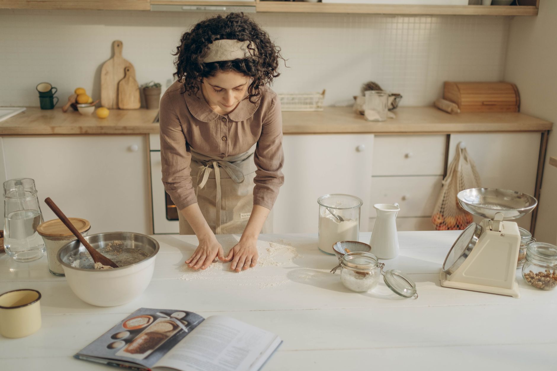A baker reviewing research and notes on her laptop in her bakery