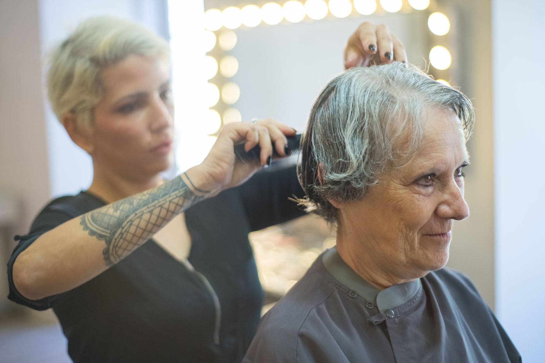 A hairdresser sharing a genuine laugh with a regular client