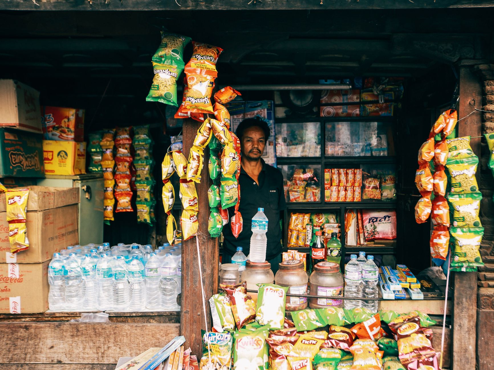 A shop owner surrounded by unsold flyers and stock