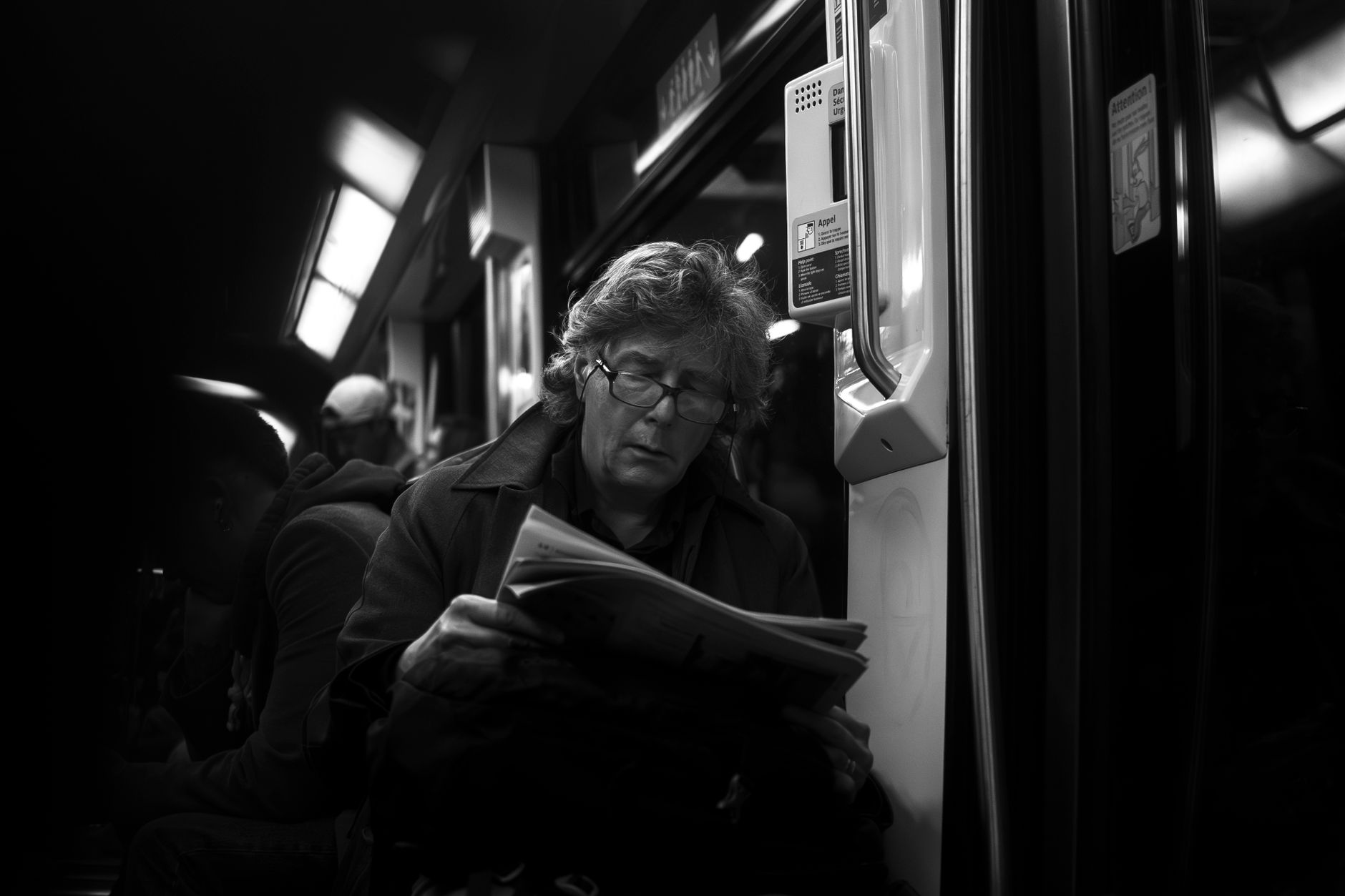 A commuter reading news with a sceptical expression