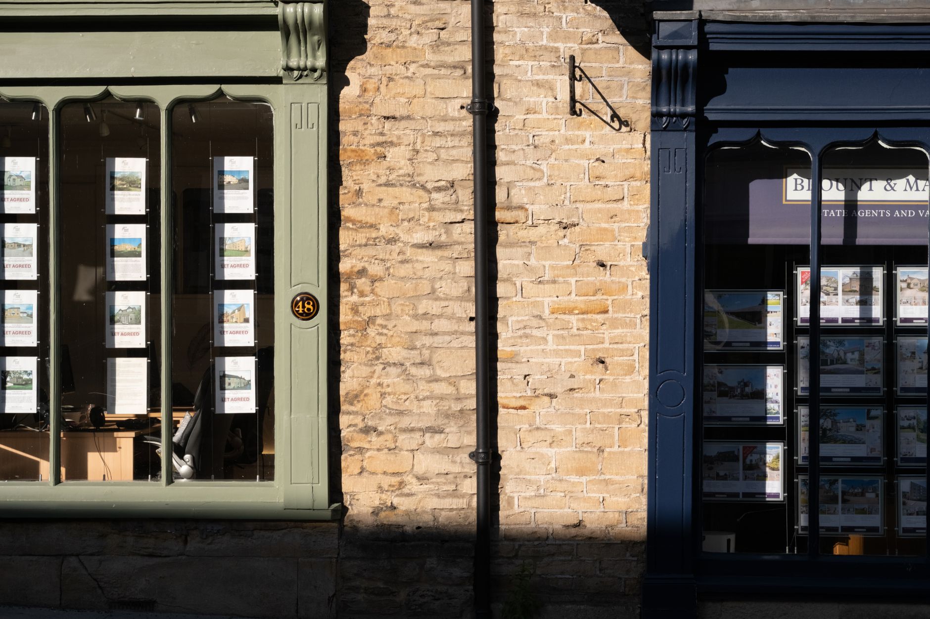 An independent estate agent couple outside their small town office