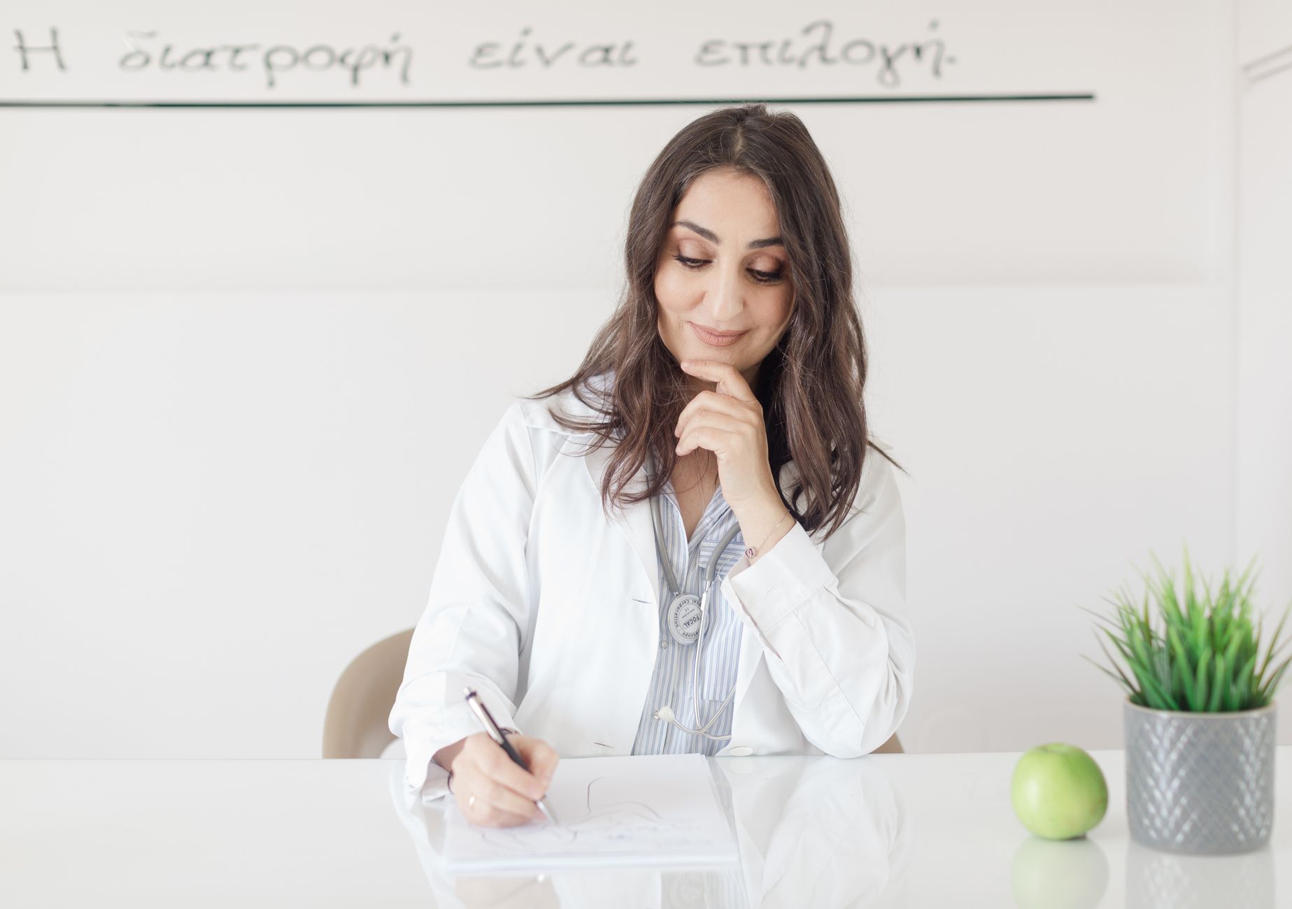 A nutritionist making notes during a one-to-one consultation