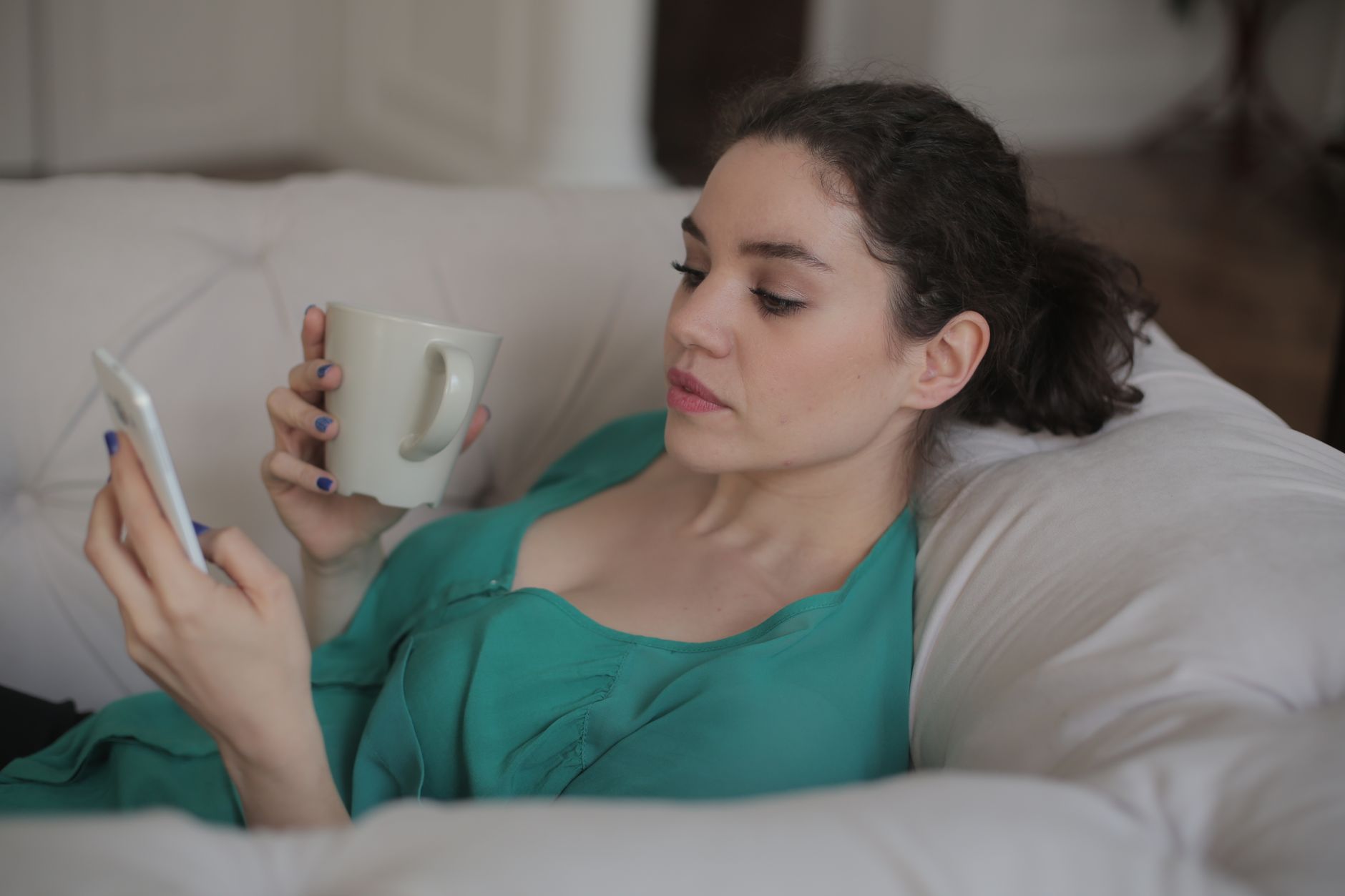 A woman relaxing at home and watching a video on her phone