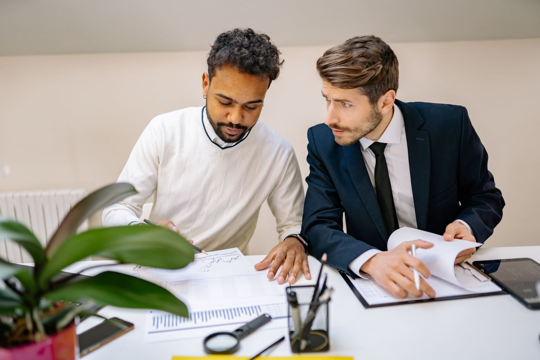 Two colleagues reviewing how their videos performed at a desk