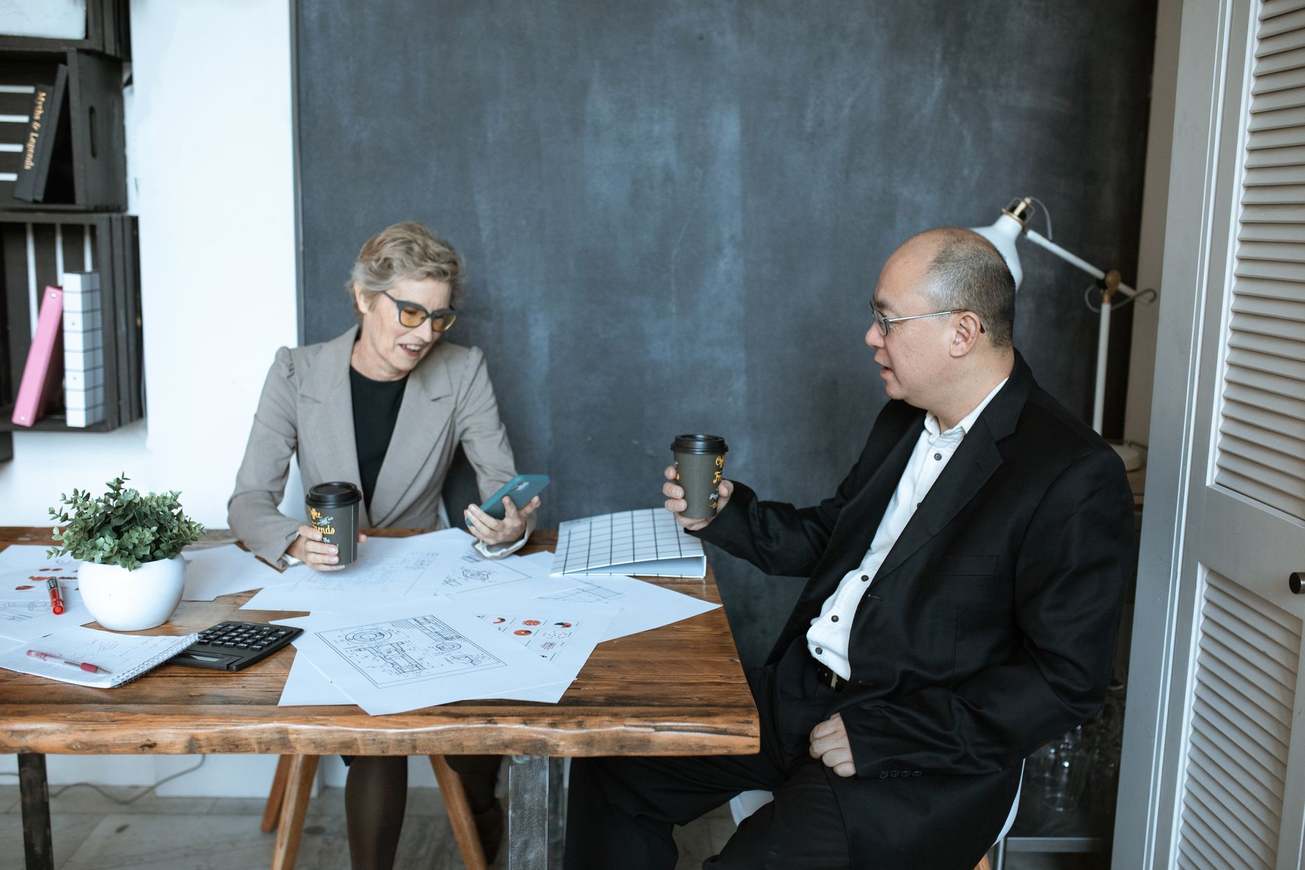 Two colleagues planning their marketing together over coffee at a table