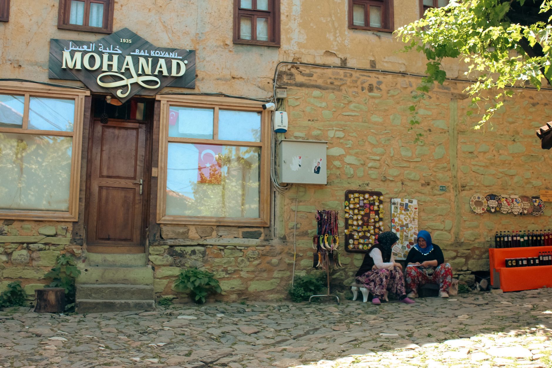 Two independent shop owners talking outside their businesses