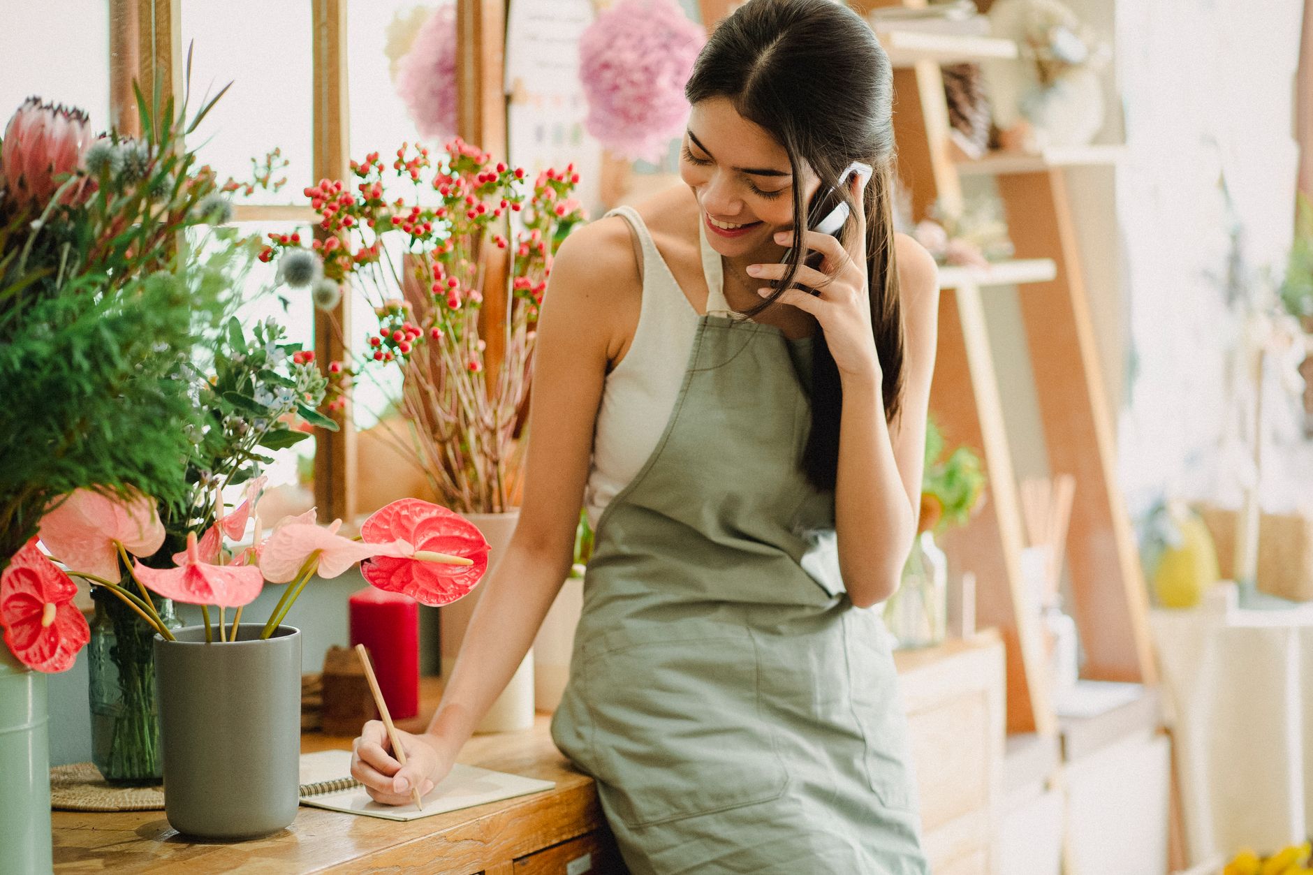 A shop owner checking her phone behind an empty till