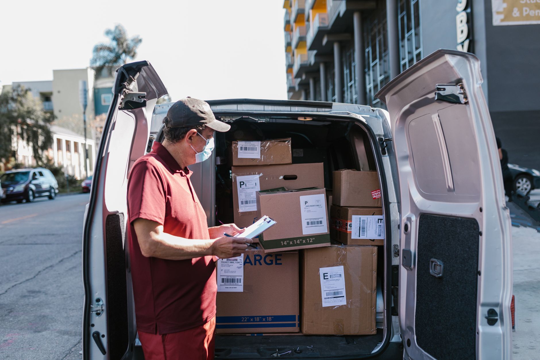 A plumber reviewing his job list beside his van