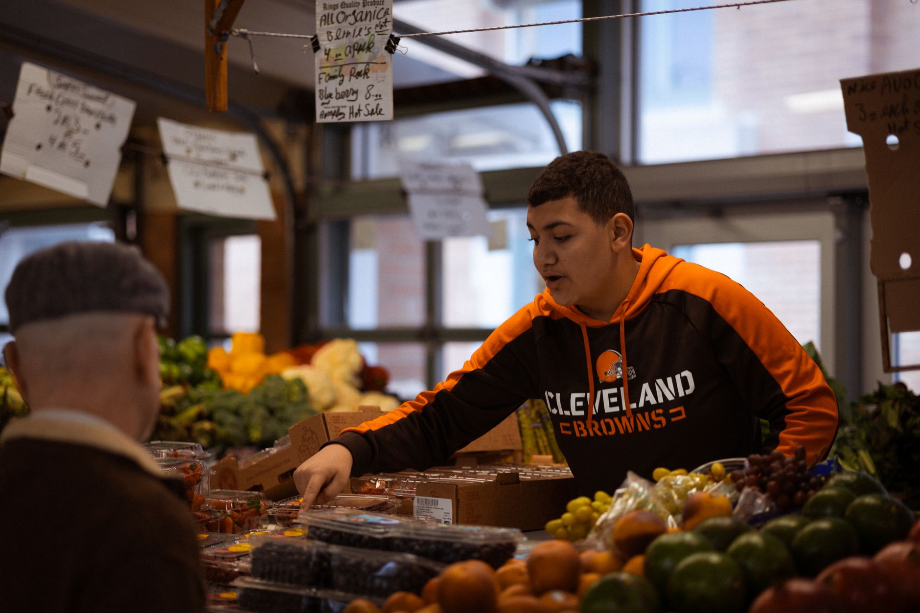 A market trader sharing a joke with a regular customer