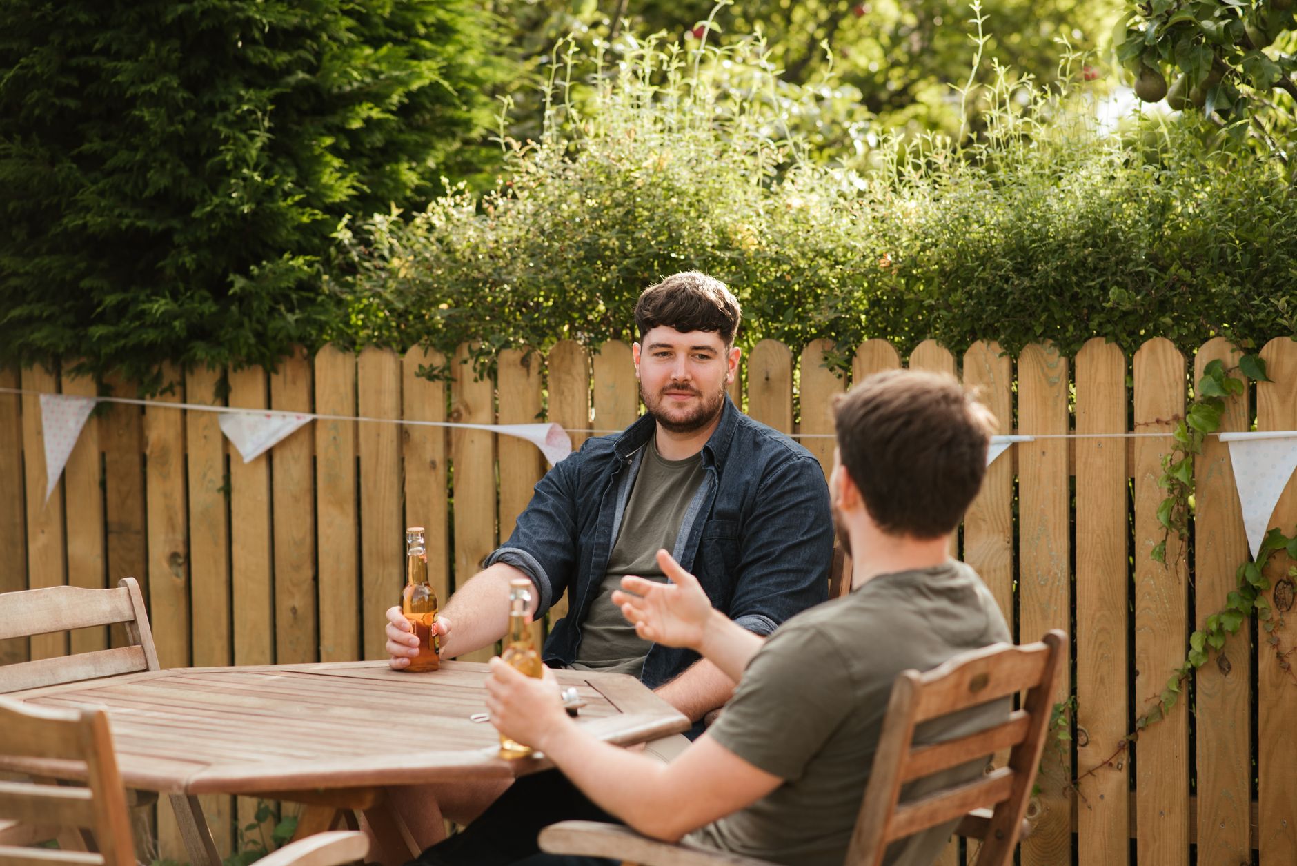 Two neighbours talking outside their homes on a residential street